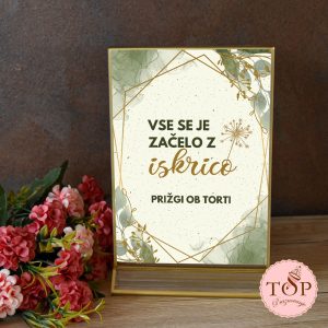 Tablica z napisom v zlatem šestkotniku: Vse se je začelo z iskrico. Prižgi ob torti.